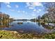 Tranquil lake view featuring a wooden dock, calm waters, and lush greenery, offering a serene and peaceful setting at 17119 Rainbow Ter, Odessa, FL 33556