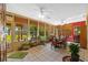 Bright sunroom with tile floors, ceiling fans, large windows, and a view of the lake and landscaped yard at 17119 Rainbow Ter, Odessa, FL 33556