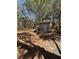 Exterior view of stone outbuilding on property with surrounding trees, foliage, and a peek at the car at 17233 Dalberg Dr, Spring Hill, FL 34610