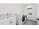 Laundry room features modern washer and dryer, sink and storage space at 1956 Cedar Dr, Dunedin, FL 34698