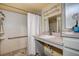 Well-lit bathroom featuring a single sink vanity, tiled shower, and accessible grab bar at 2343 Wilshire Dr, Dunedin, FL 34698