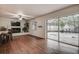 Bright living room with a brick fireplace, sliding glass doors to the patio, and wood laminate flooring at 2343 Wilshire Dr, Dunedin, FL 34698