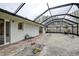 Covered patio area with stone flooring, a table and chairs, and views of the backyard at 2343 Wilshire Dr, Dunedin, FL 34698