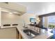 Open kitchen area shows a stainless steel sink and view of the living area and ocean beyond at 2506 N Rocky Point Dr # 242, Tampa, FL 33607