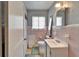Quaint bathroom features pink and white tile, a vanity sink, toilet, and a shower with a curtain at 2606 N Boulevard, Tampa, FL 33602