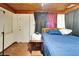 Simple bedroom features a bed with blue linens and a rustic wood ceiling, offering a cozy retreat at 2606 N Boulevard, Tampa, FL 33602