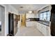 Functional kitchen features white cabinets, laminate countertops, a black refrigerator, and essential appliances at 2606 N Boulevard, Tampa, FL 33602