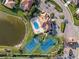 An aerial view shows the community pool, tennis courts, and nearby pond at 2769 Harvest Drive, Sarasota, FL 34240