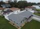 Aerial view of a home with a gray roof and blue shutters surrounded by a well-maintained lawn at 302 N Lauber Way, Tampa, FL 33609