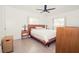 Well lit bedroom with wood-look floors, ceiling fan, and neutral walls at 302 N Lauber Way, Tampa, FL 33609