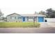 Charming single-story home featuring a stone facade, bright blue shutters and door, and a well-manicured front lawn at 302 N Lauber Way, Tampa, FL 33609