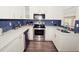 Well-lit kitchen with white cabinets, stainless steel appliances, and a stylish backsplash at 302 N Lauber Way, Tampa, FL 33609