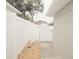 Enclosed side yard with a white fence, decorative dog statue, and gated entrance at 302 N Lauber Way, Tampa, FL 33609