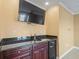 Featuring a wet bar with granite countertop, mini fridge, and wood cabinetry at 3447 Flamingo Blvd, Hernando Beach, FL 34607