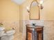 Elegant powder room with marble floors, granite countertop, and decorative mirror at 3447 Flamingo Blvd, Hernando Beach, FL 34607