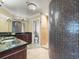 Luxurious bathroom with dark granite countertops, dual vanity, mosaic shower and tile flooring at 3447 Flamingo Blvd, Hernando Beach, FL 34607