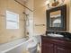 Well-lit bathroom with a large mirror, granite countertops, and tiled shower over tub at 3447 Flamingo Blvd, Hernando Beach, FL 34607