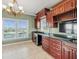 Butler's pantry area featuring wooden cabinets, granite countertops, a wine fridge, and waterfront views at 3447 Flamingo Blvd, Hernando Beach, FL 34607