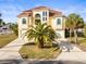 Stunning two-story home with a tile roof, a well-manicured lawn, and a palm tree in the front yard at 3447 Flamingo Blvd, Hernando Beach, FL 34607