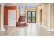 Grand foyer featuring a wood staircase, decorative columns, and a double-door entryway with glass panels at 3447 Flamingo Blvd, Hernando Beach, FL 34607