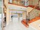 Spacious foyer showcasing an elegant wood staircase, tile flooring, and an open layout into the living areas at 3447 Flamingo Blvd, Hernando Beach, FL 34607