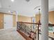 Upstairs hallway with hardwood steps, iron railing, and natural light from arched window at 3447 Flamingo Blvd, Hernando Beach, FL 34607
