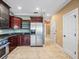 Well-lit kitchen featuring dark wood cabinets, stainless steel appliances, and tiled floors at 3447 Flamingo Blvd, Hernando Beach, FL 34607