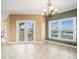 Living room featuring access to an outdoor balcony, a large window, and a decorative chandelier at 3447 Flamingo Blvd, Hernando Beach, FL 34607