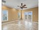 Spacious living room with tile flooring, ceiling fan, and access to an outdoor balcony with water views at 3447 Flamingo Blvd, Hernando Beach, FL 34607