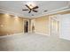 Spacious main bedroom features neutral carpet, a ceiling fan, and doorway to en-suite bathroom and walk-in closet at 3447 Flamingo Blvd, Hernando Beach, FL 34607