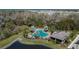 Aerial view showcasing a vibrant pool area and clubhouse in a lush community setting at 36707 Goffaux Loop, Zephyrhills, FL 33541