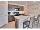 Kitchen with island featuring seating, dark wood cabinets, a black cooktop, and stainless steel appliances at 36707 Goffaux Loop, Zephyrhills, FL 33541