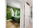 Cozy green bedroom with hardwood floors and an open door to the bathroom at 3765 21St S Ave, St Petersburg, FL 33711