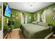 Green bedroom with large bed, wood floors, and natural light from the windows at 3765 21St S Ave, St Petersburg, FL 33711