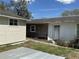 Exterior of a house with a detached garage, a door, and a gray slab in the back at 38714 C Ave, Zephyrhills, FL 33542