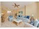 Staged living room with plush sofa, light blue decor, ceiling fan, and bright natural light at 4216 Preserve Pl, Palm Harbor, FL 34685