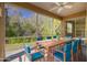 Staged screened lanai with outdoor dining set and peaceful view of a green wooded area at 4216 Preserve Pl, Palm Harbor, FL 34685