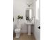 Stylish powder room with pedestal sink, modern fixtures, and neutral tones at 440 Capri Ne Way, St Petersburg, FL 33704