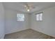 This bedroom has two windows, wood-look floors, neutral walls, and a ceiling fan at 4750 Keysville Ave, Spring Hill, FL 34608