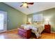 Comfortable bedroom features ceiling fan, light green walls, and wood-look laminate flooring at 510 Pine S Ave, Oldsmar, FL 34677