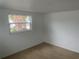 Bright bedroom featuring neutral carpet, white walls, and window overlooking the exterior at 5253 Falcon Dr, Holiday, FL 34690