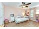 Whimsical bedroom with pink walls, a white bed frame, and a ceiling fan at 5411 Starling Ridge Dr, Lithia, FL 33547