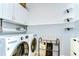 Well-organized laundry room with white cabinets, modern washer and dryer, and shelving for convenient storage at 5411 Starling Ridge Dr, Lithia, FL 33547