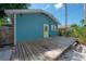 A cozy blue home with a yellow door and a spacious wooden deck at 5603 N Taliaferro Ave, Tampa, FL 33604