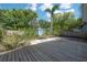 A serene backyard featuring a spacious wooden deck, shed, and lush greenery at 5603 N Taliaferro Ave, Tampa, FL 33604