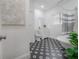 Bright bathroom with black and white floors, tub, white vanity and elegant finishes at 5603 N Taliaferro Ave, Tampa, FL 33604