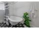 Close up of a bright white bathroom with a vintage claw foot tub and patterned floor at 5603 N Taliaferro Ave, Tampa, FL 33604