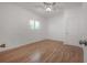 Bright bedroom featuring hardwood floors, a ceiling fan and a window at 5603 N Taliaferro Ave, Tampa, FL 33604