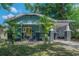 Charming home featuring a light blue exterior with a yellow front door and a welcoming covered porch at 5603 N Taliaferro Ave, Tampa, FL 33604