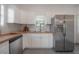 Kitchen boasts white cabinets, stainless steel appliances, butcher block countertops, and hexagon tile flooring at 5603 N Taliaferro Ave, Tampa, FL 33604